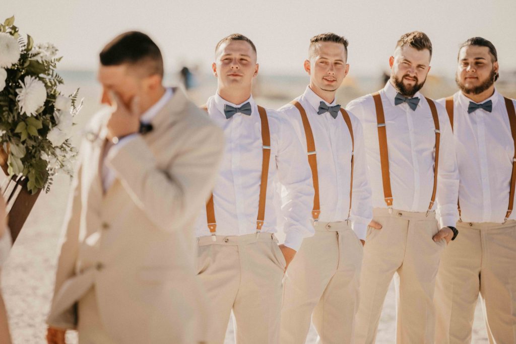 groomsmen looking at the groom crying emotionally