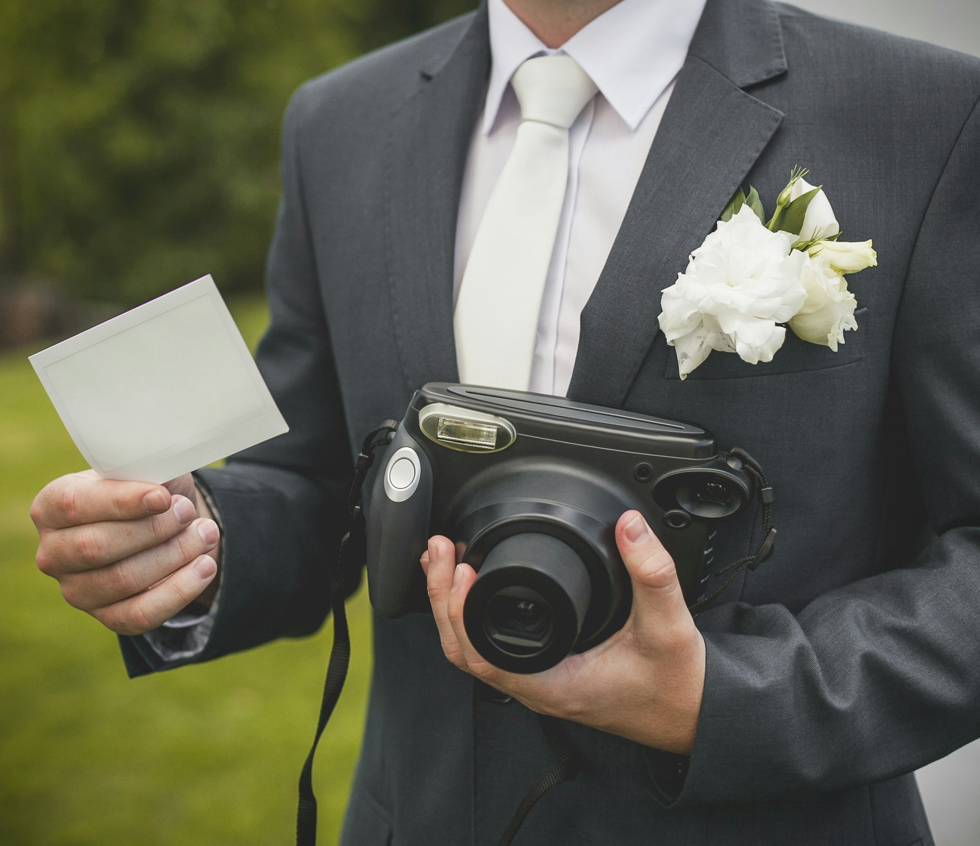 Part of groom with retro camera and empty card