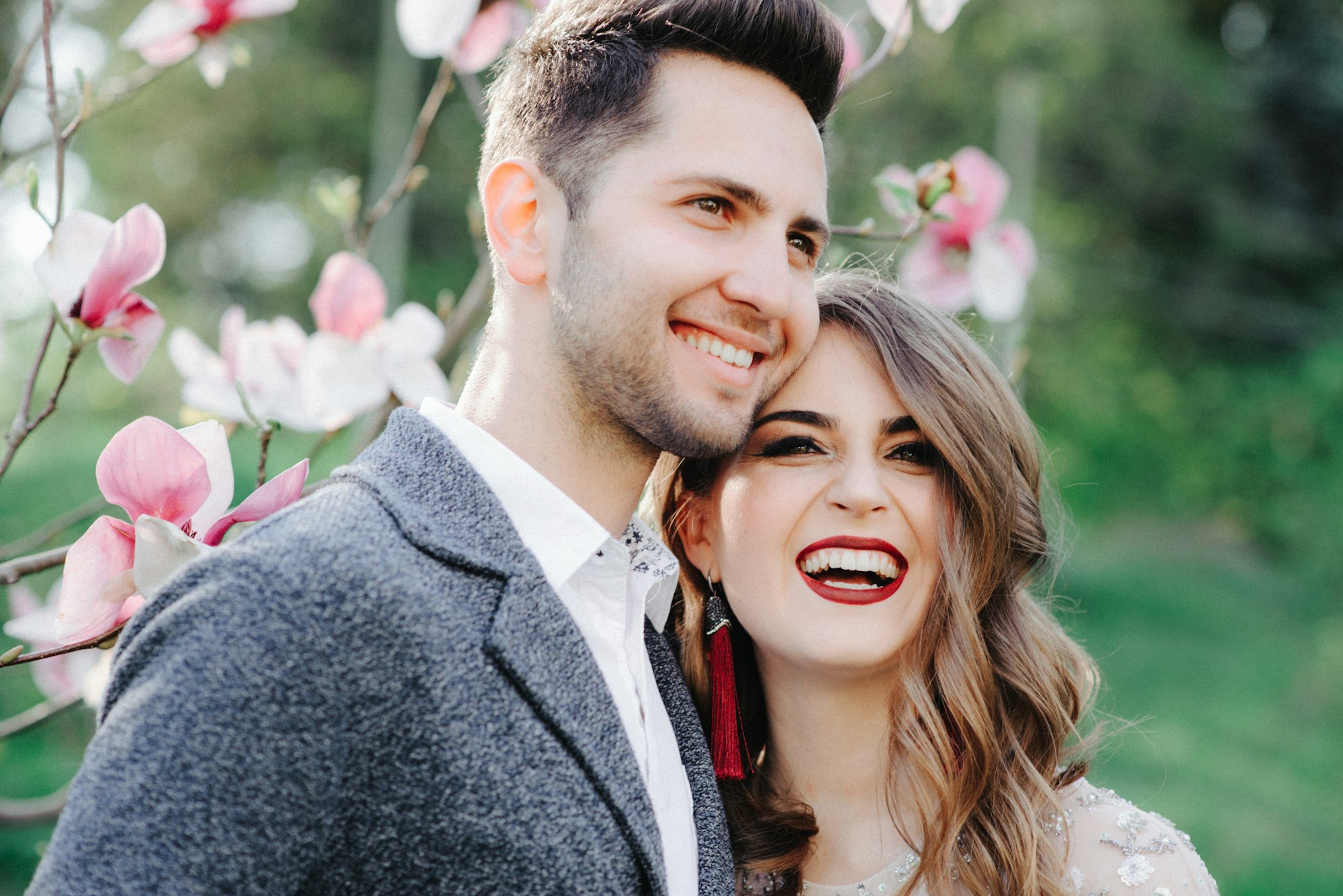 Sunshine portrait of happy bride and groom outdoor in nature location at sunset. Warm summertime